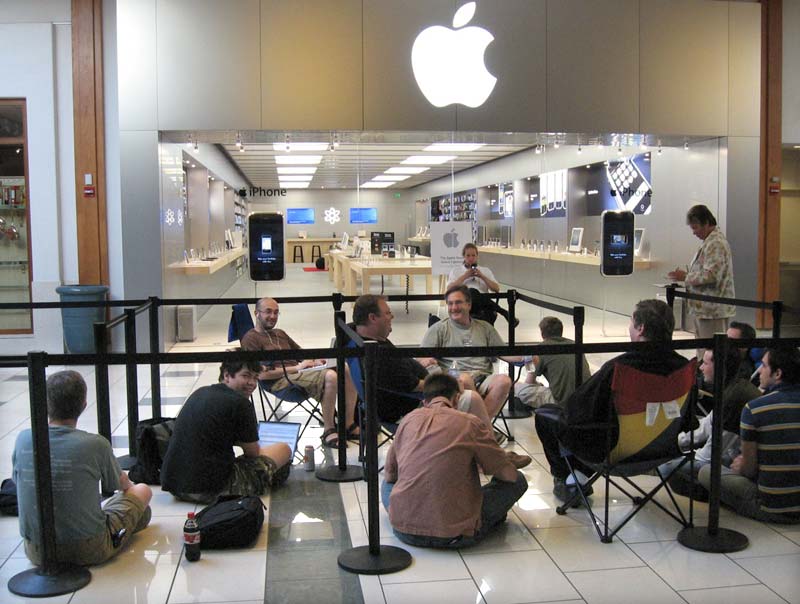 people sitting and waiting outside Apple store